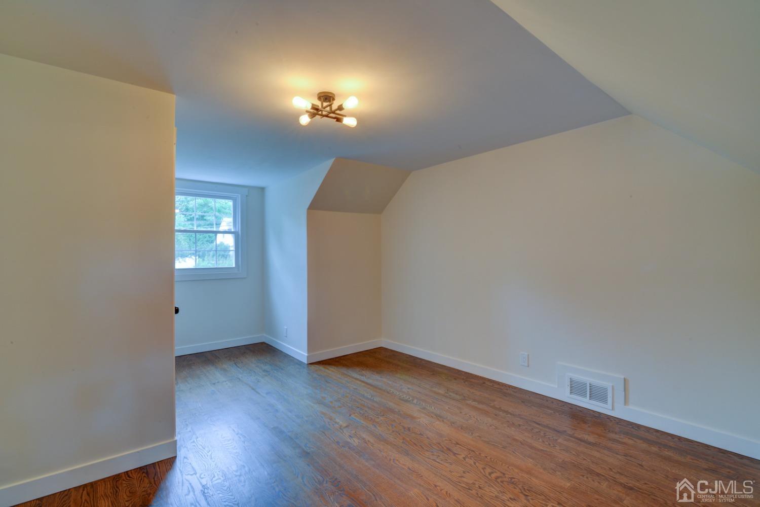 420 Chain O' Hills Road Colonia, NJ 07067 - Photo 22 of 37 a view of an empty room with wooden floor and a window