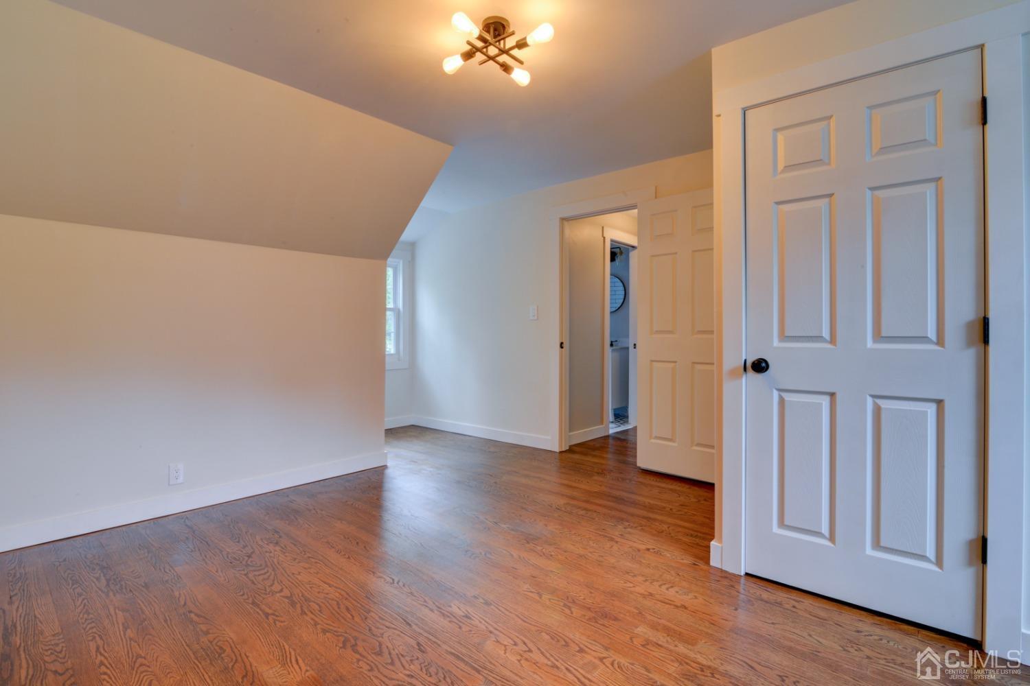 420 Chain O' Hills Road Colonia, NJ 07067 - Photo 23 of 37 a view of a hallway with wooden floor and chandelier