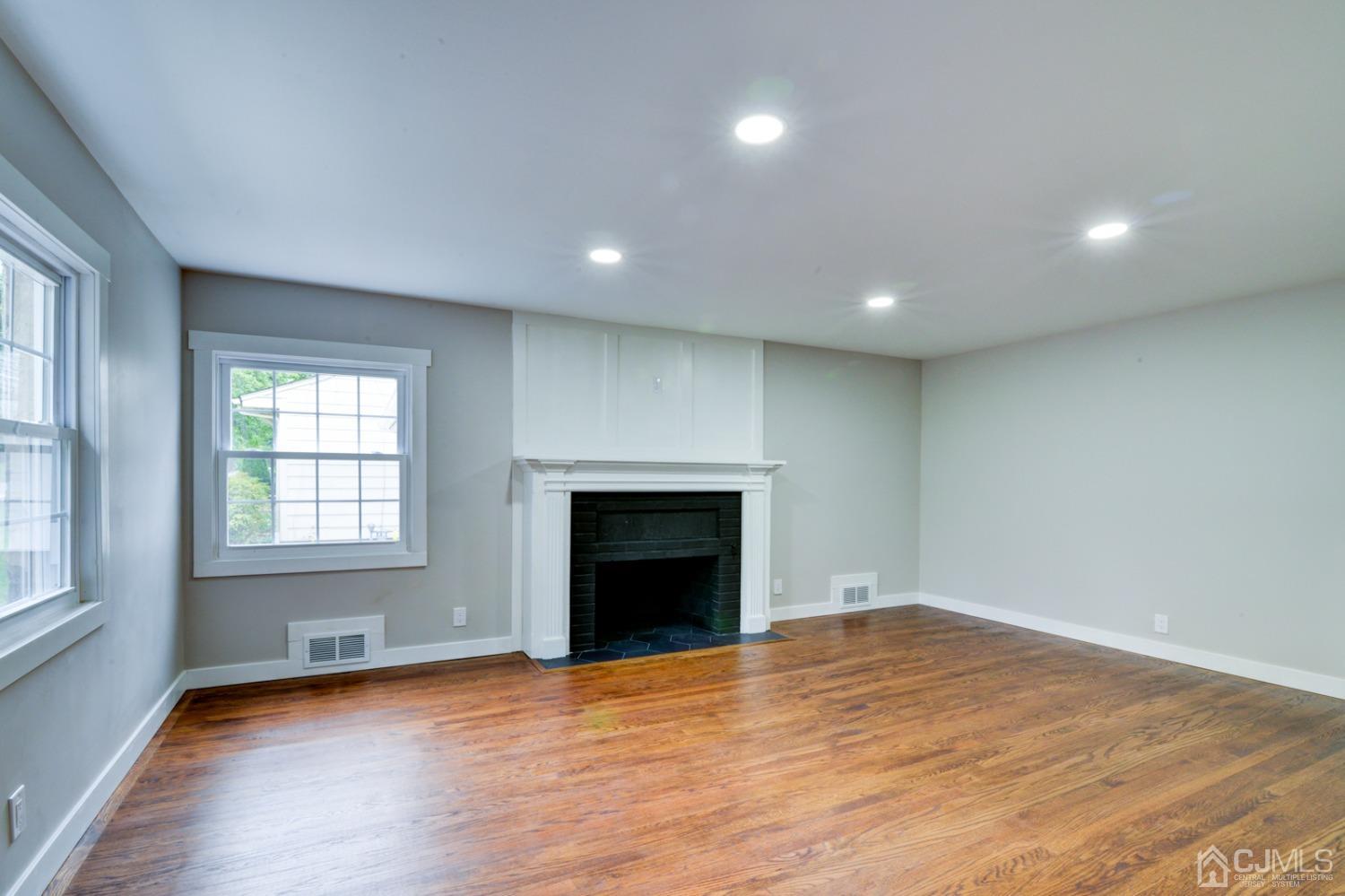 420 Chain O' Hills Road Colonia, NJ 07067 - Photo 5 of 37 an empty room with wooden floor fireplace and windows