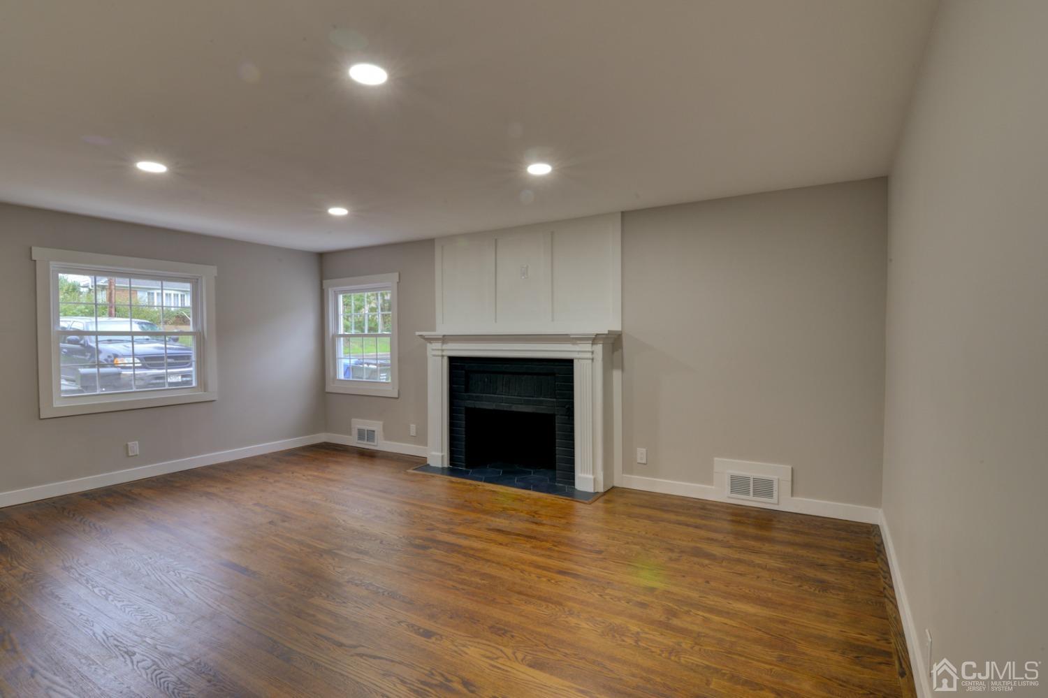 420 Chain O' Hills Road Colonia, NJ 07067 - Photo 8 of 37 an empty room with wooden floor fireplace and windows