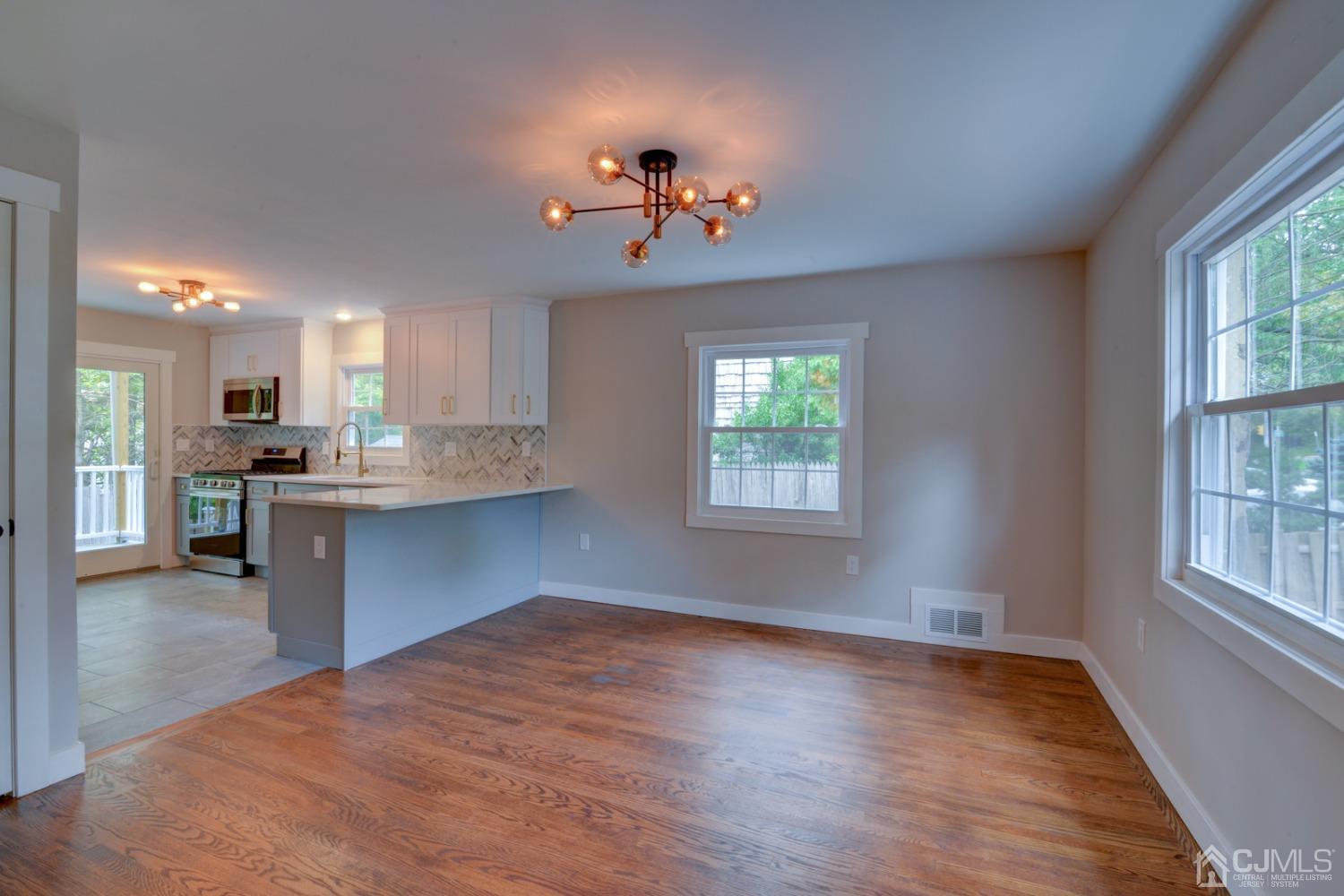 420 Chain O' Hills Road Colonia, NJ 07067 - Photo 9 of 37 a open kitchen with kitchen island a stove a sink dishwasher and a refrigerator with wooden floor