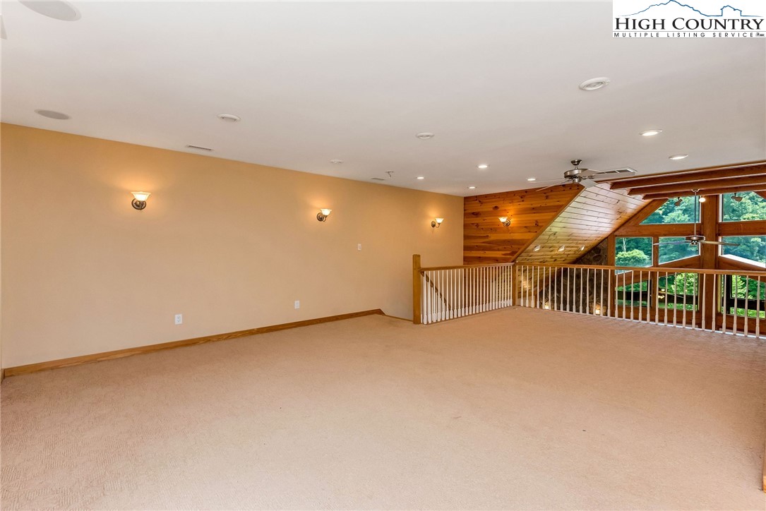 453 South River Hills Road Lansing, NC 28643 - Photo 33 of 48 an empty room with large windows and stairs