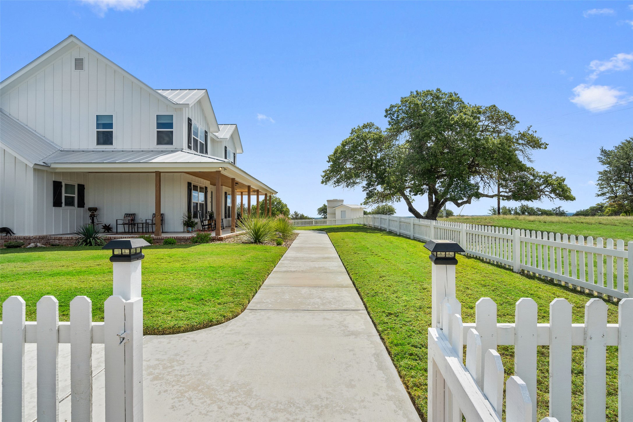 2454 McKinney Loop Blanco, TX 78606 - Photo 15 of 21 a view of a house with a small yard and a large tree
