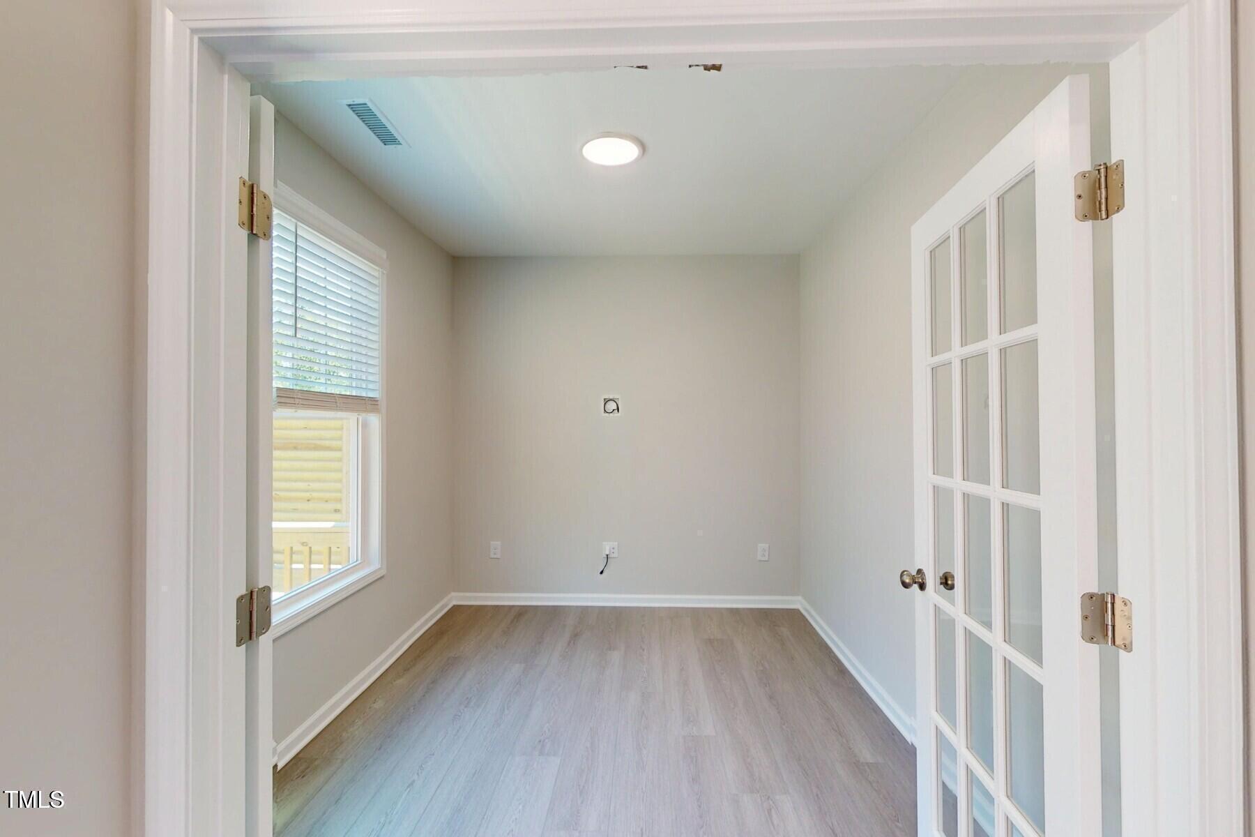 2209 Lambert Road Cary, NC 27519 - Photo 12 of 51 a view of an empty room with wooden floor and a window