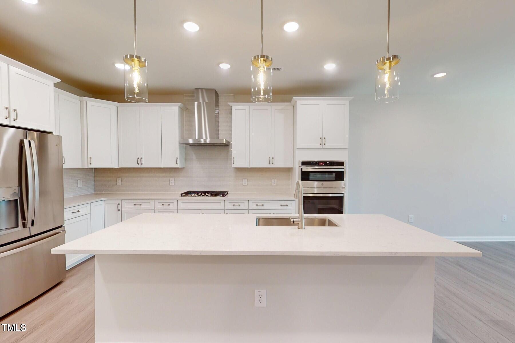 2209 Lambert Road Cary, NC 27519 - Photo 14 of 51 a kitchen with kitchen island white cabinets and stainless steel appliances