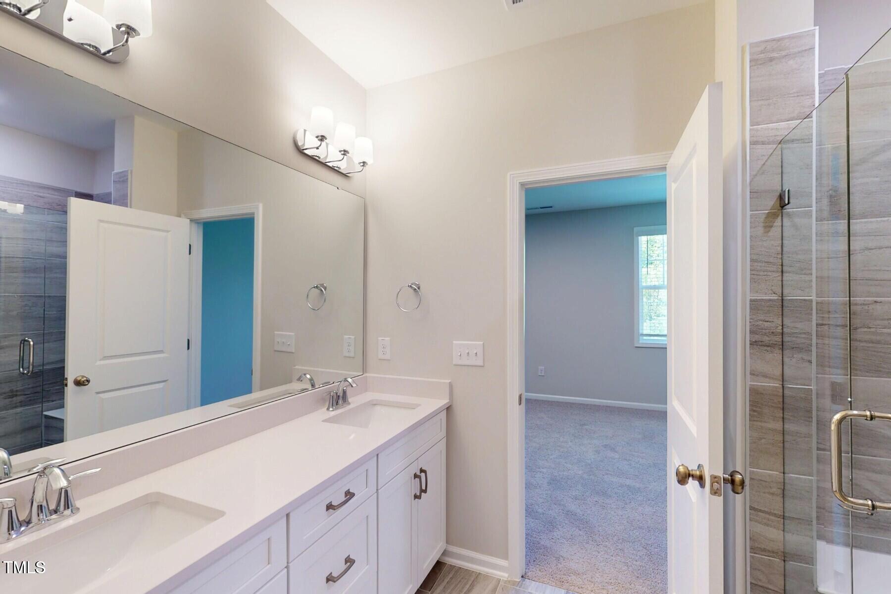 2209 Lambert Road Cary, NC 27519 - Photo 27 of 51 a bathroom with a double vanity sink a mirror and a shower
