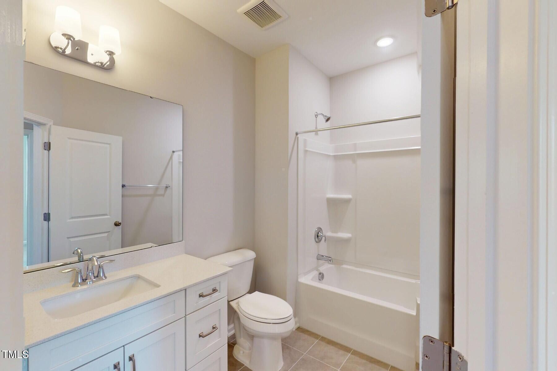 2209 Lambert Road Cary, NC 27519 - Photo 40 of 51 a bathroom with a sink a toilet and a large mirror