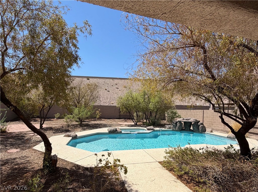 728 Blue Crystal Creek Road Henderson, NV 89002 - Photo 2 of 2 An inviting private pool and spa oasis awaits, surrounded by mature desert landscaping.