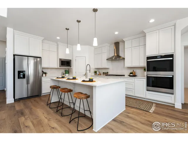 a kitchen with stainless steel appliances kitchen island granite countertop a stove a sink a refrigerator and a microwave