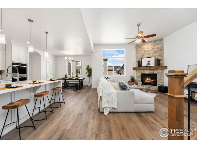 a living room with furniture a fireplace and kitchen view
