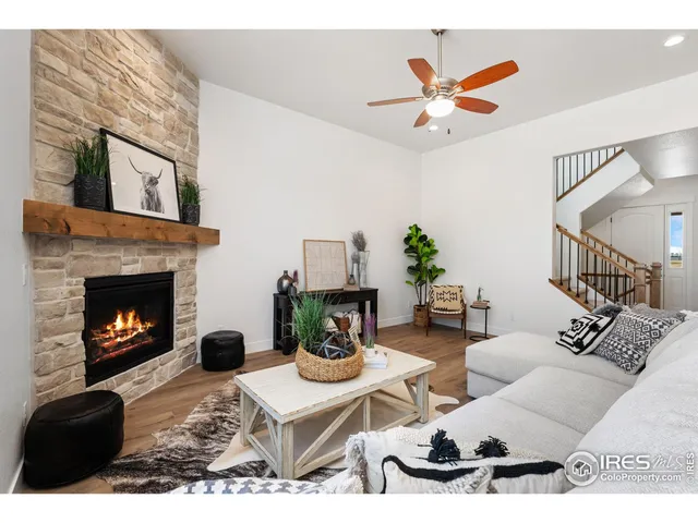 a living room with furniture a fireplace and a ceiling fan