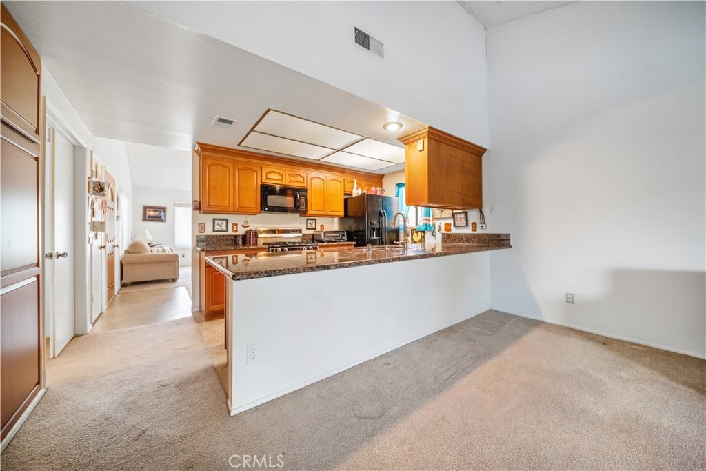 6275 Sapphire Street Rancho Cucamonga, CA 91701 - Photo 13 of 32 a room with stainless steel appliances kitchen island granite countertop a refrigerator and a sink
