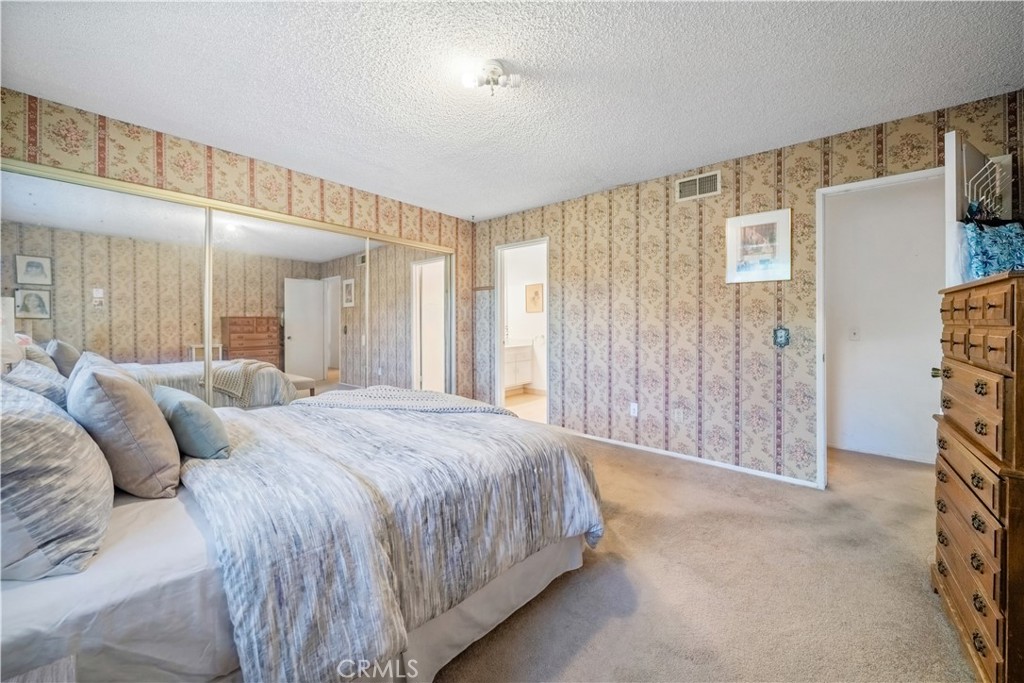 6275 Sapphire Street Rancho Cucamonga, CA 91701 - Photo 26 of 32 a spacious bedroom with a bed a lamp and a large window