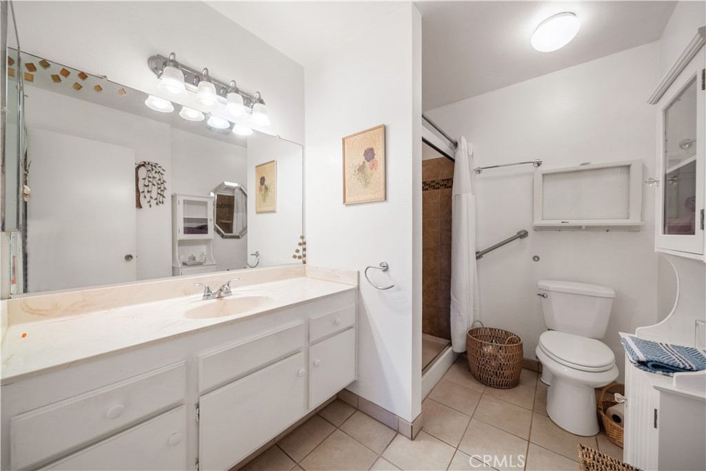 6275 Sapphire Street Rancho Cucamonga, CA 91701 - Photo 27 of 32 a bathroom with a toilet sink and mirror