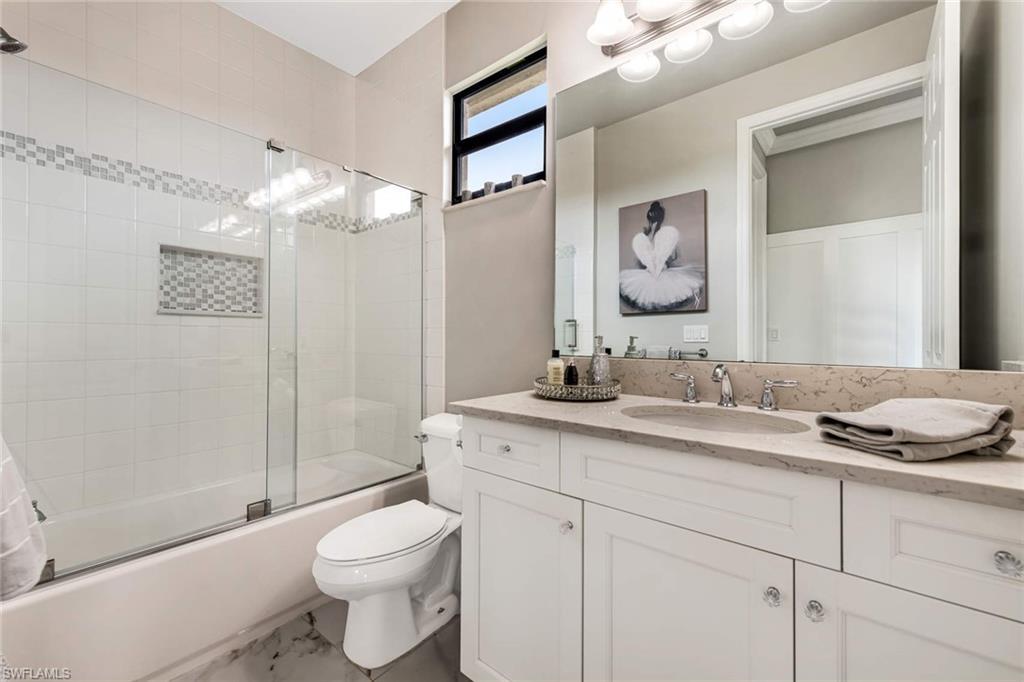 4347 Avalon Court Naples, FL 34119 - Photo 15 of 22 a bathroom with a granite countertop sink mirror vanity and toilet