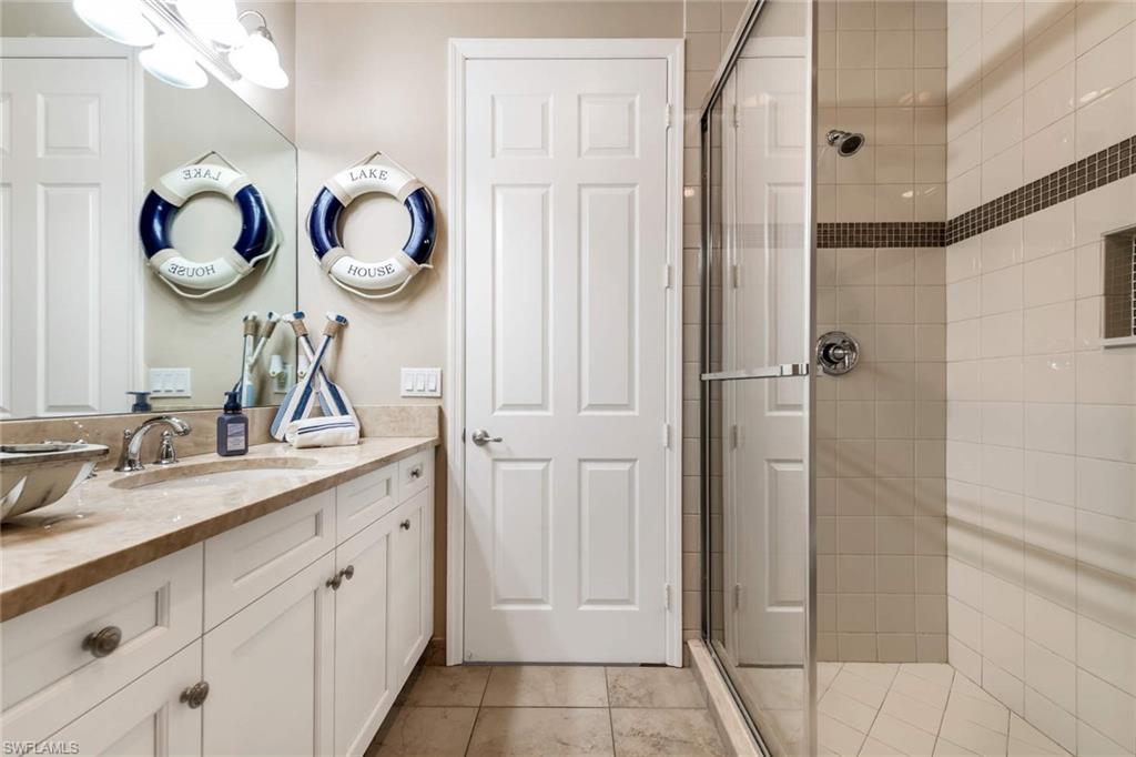 4347 Avalon Court Naples, FL 34119 - Photo 19 of 22 a bathroom with a double vanity sink and a mirror