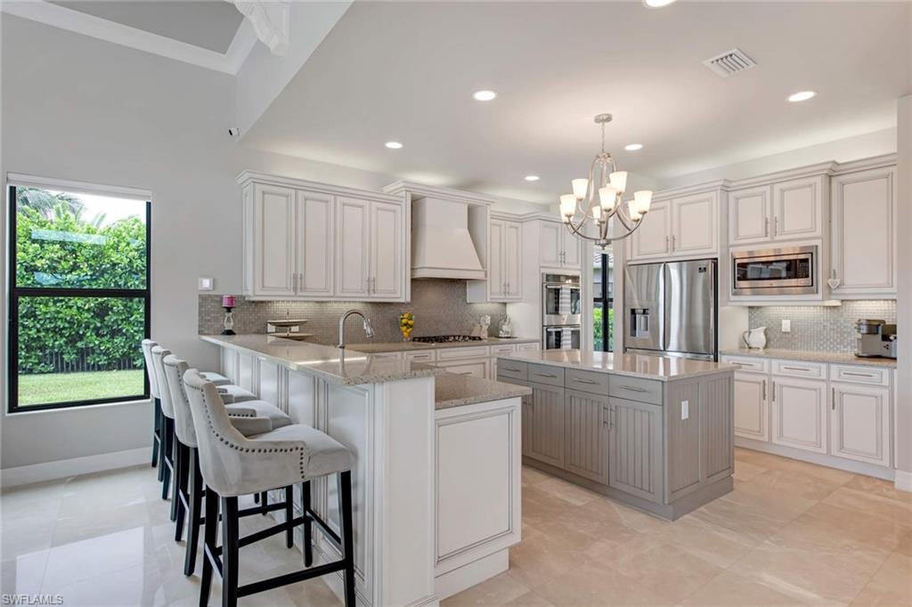 4347 Avalon Court Naples, FL 34119 - Photo 4 of 22 a kitchen with kitchen island granite countertop white cabinets and stainless steel appliances