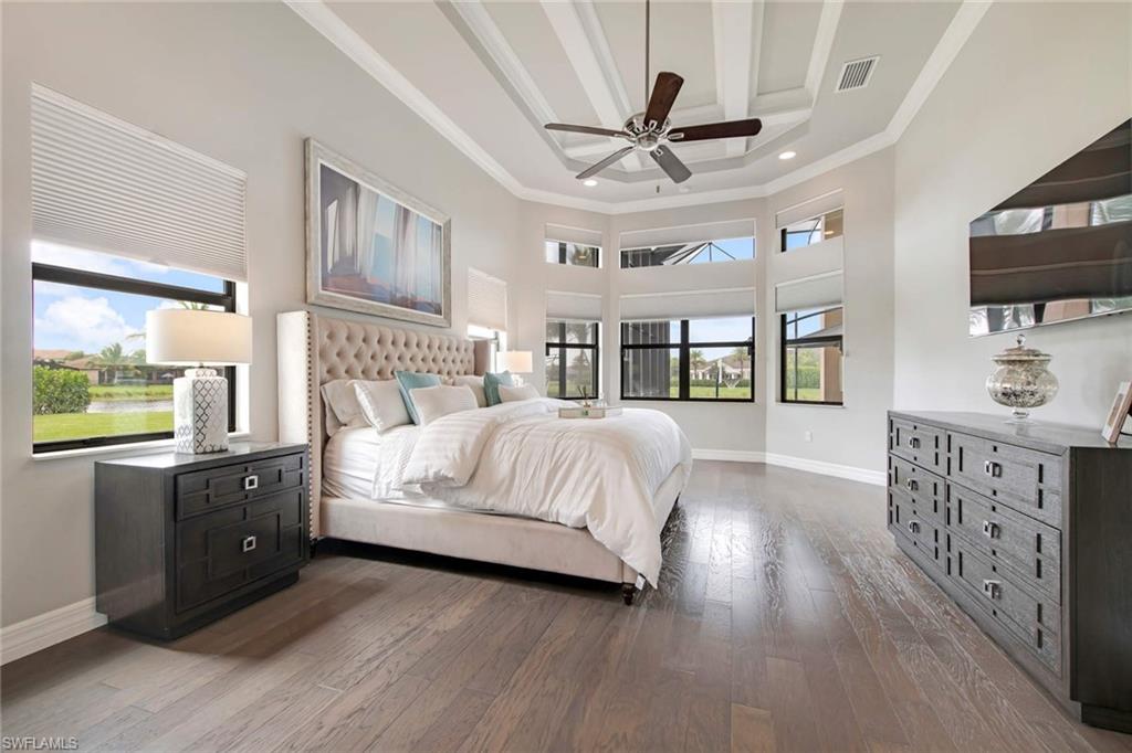 4347 Avalon Court Naples, FL 34119 - Photo 8 of 22 a bedroom with a large bed a flat tv screen and a dresser