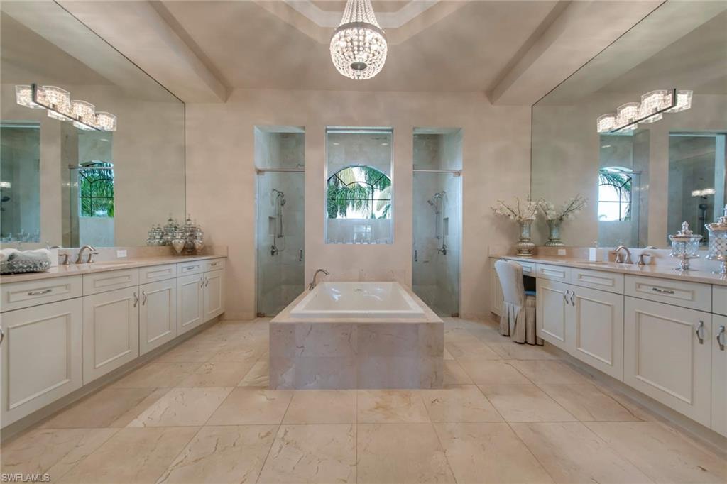 4347 Avalon Court Naples, FL 34119 - Photo 9 of 22 a spacious bathroom with a granite countertop sink a toilet a mirror and vanity