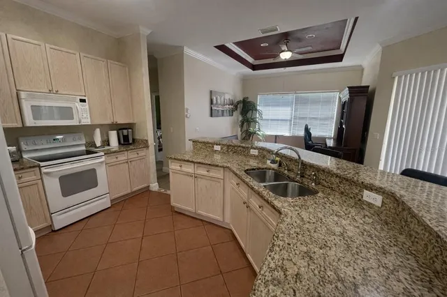 a kitchen with granite countertop a sink a stove and cabinets