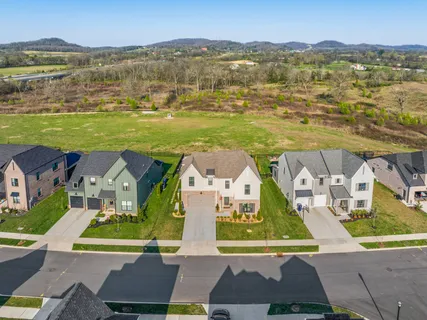 an aerial view of residential houses with outdoor space and ocean view