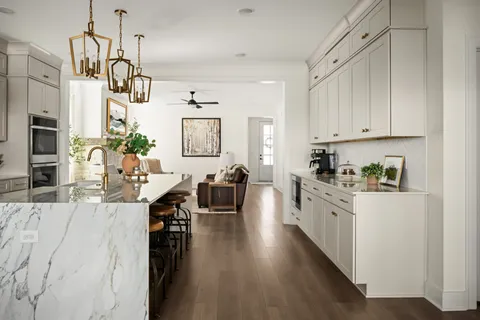 a kitchen with stainless steel appliances kitchen island granite countertop a lot of counter space and wooden floors