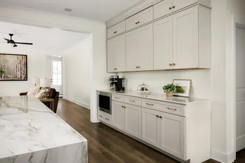 a kitchen with white cabinets and sink