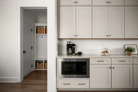 a kitchen with stainless steel appliances kitchen island granite countertop a refrigerator a stove a sink dishwasher and white cabinets with wooden floor