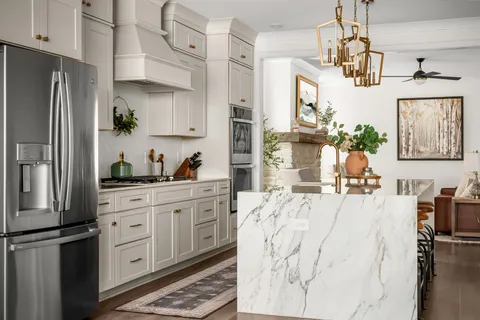 a kitchen with white cabinets and a wooden floor
