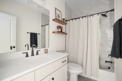 an aerial view of residential houses with outdoor space and trees