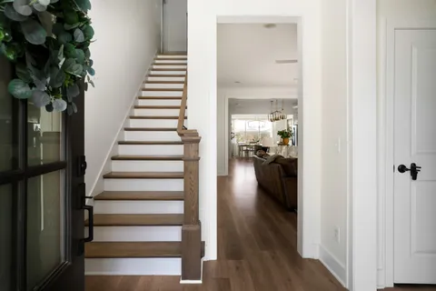 a view of a hallway with wooden floor and staircase