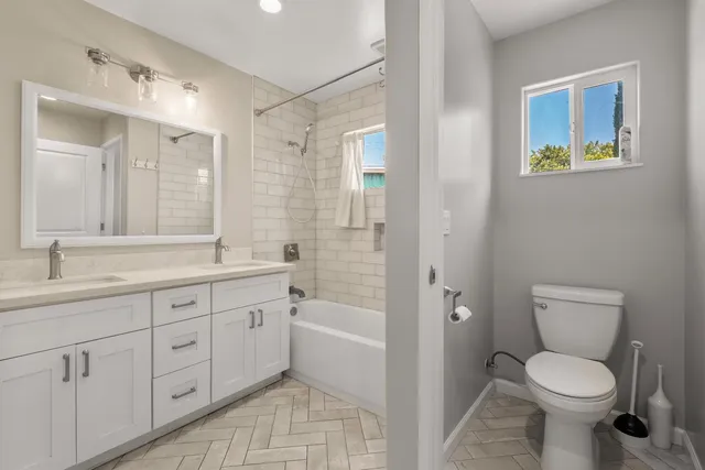 a bathroom with a toilet a sink a mirror and a bathtub