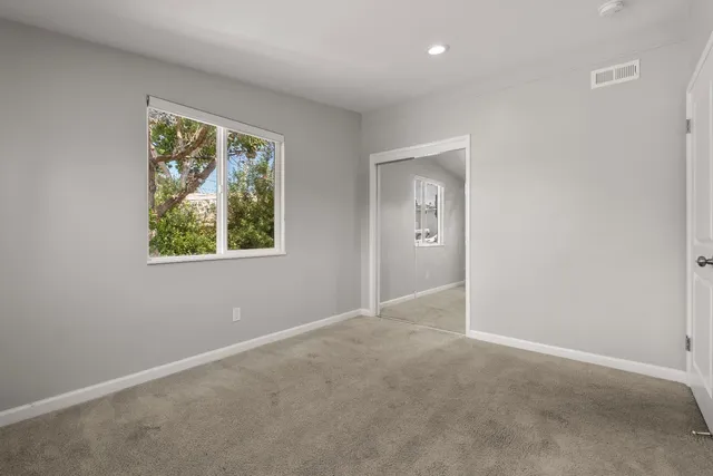 an empty room with windows and closet