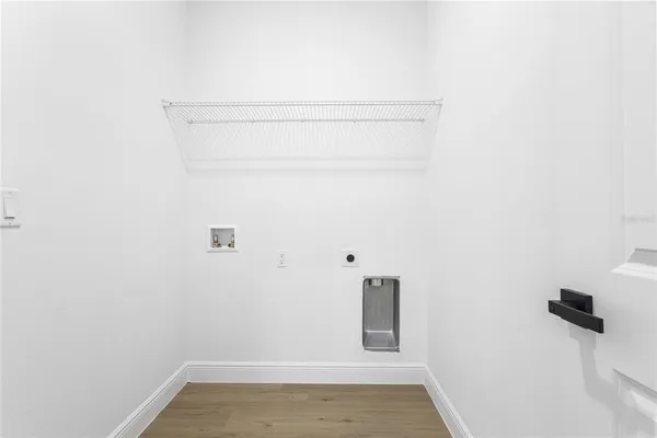 a large kitchen with stainless steel appliances kitchen island granite countertop a stove top oven a sink dishwasher and a refrigerator with wooden floor