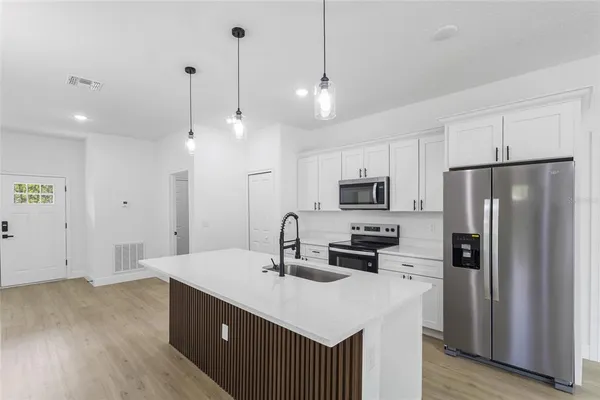 a kitchen with white cabinets and stainless steel appliances