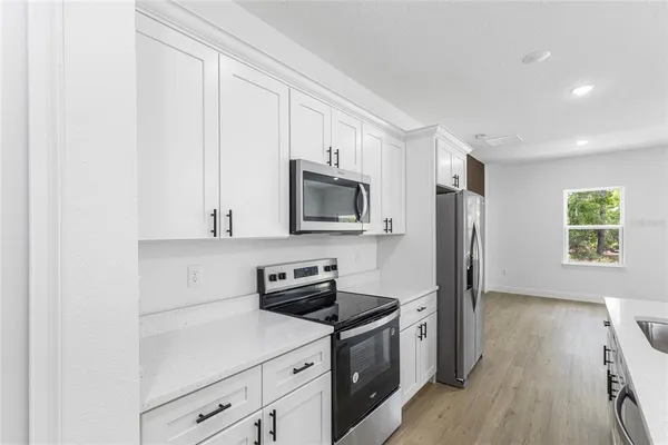 a kitchen with kitchen island a sink stainless steel appliances and cabinets