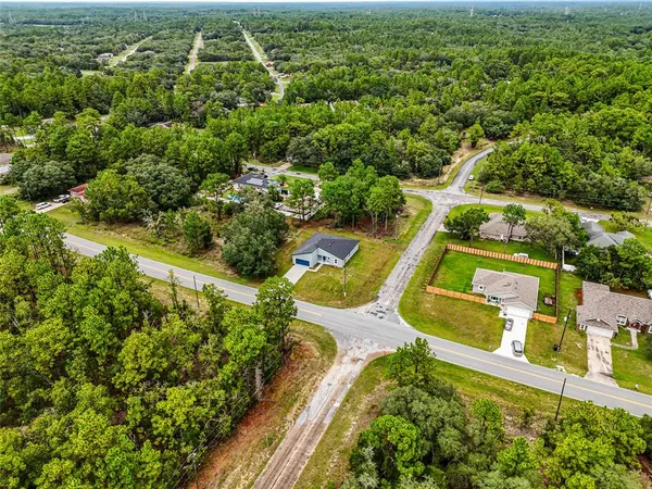 an aerial view of residential houses with outdoor space and swimming pool