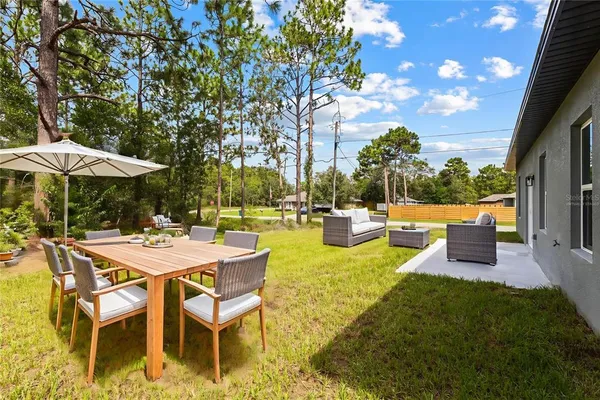 a view of a swimming pool with lawn chairs and plants