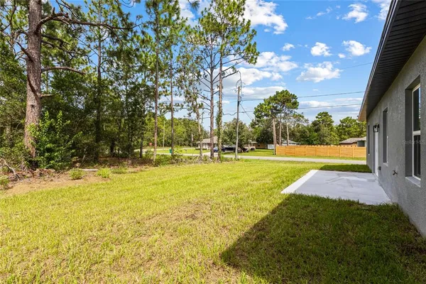 a front view of house with yard and trees in the background