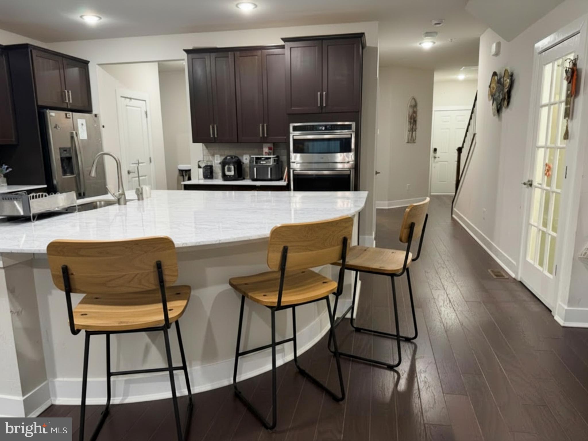 16 Lochiel Lane Exton, PA 19341 - Photo 5 of 19 a kitchen with stainless steel appliances kitchen island granite countertop a table chairs microwave and sink