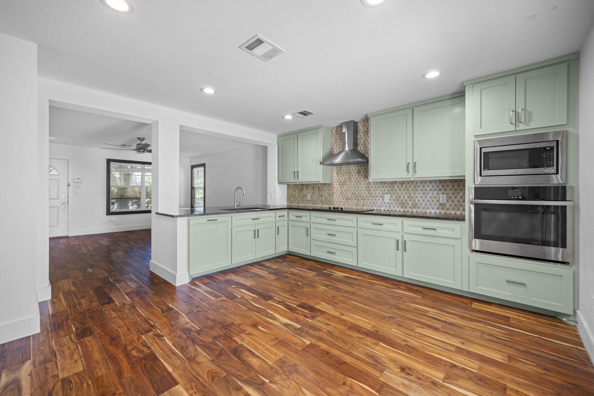 89 Jan Lane Georgetown, TX 78626 - Photo 11 of 29 Kitchen with green cabinetry, stainless steel appliances, ceiling fan, tasteful backsplash, and dark wood finished floors