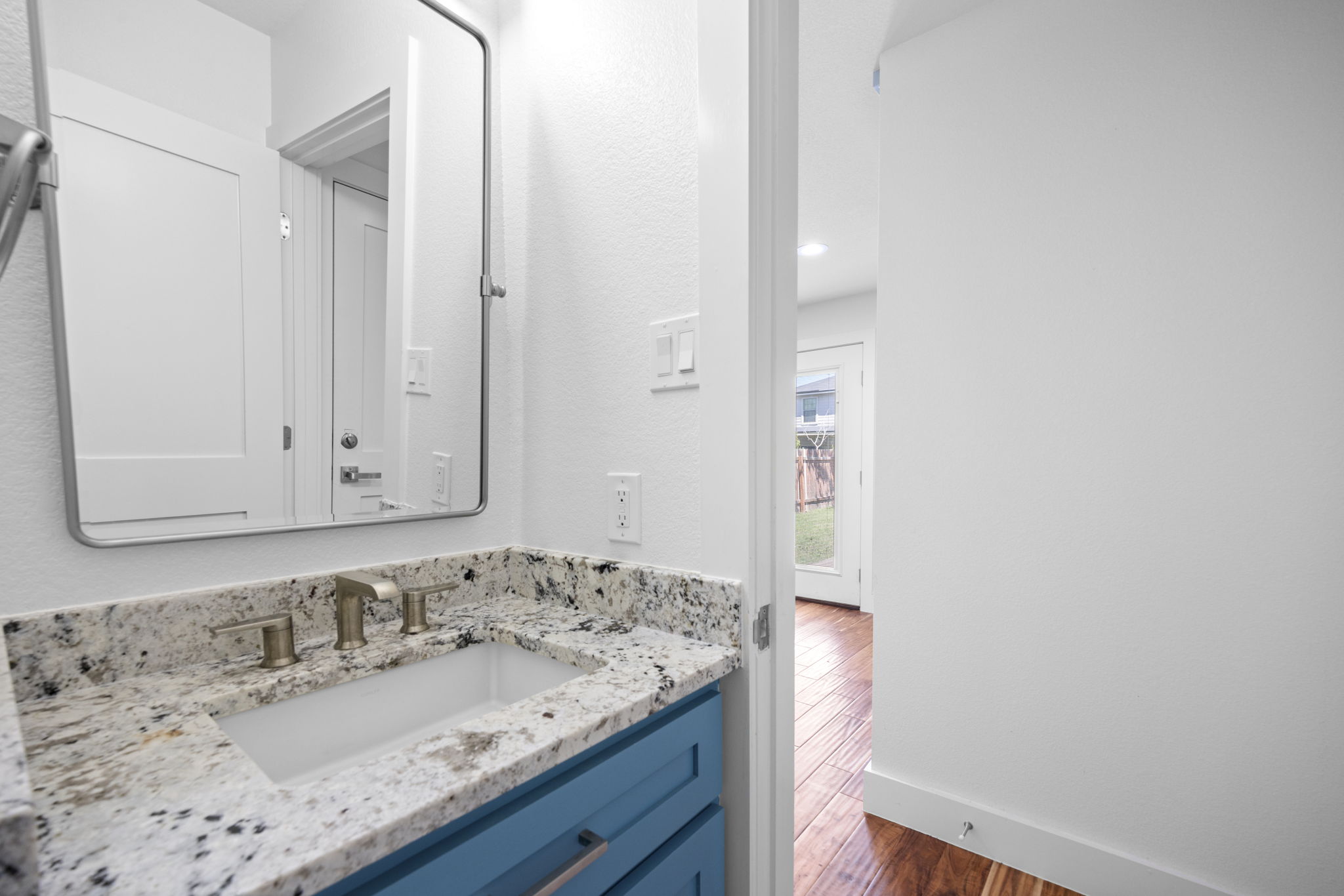 89 Jan Lane Georgetown, TX 78626 - Photo 12 of 29 Bathroom with vanity, dark wood-style flooring, and a textured wall