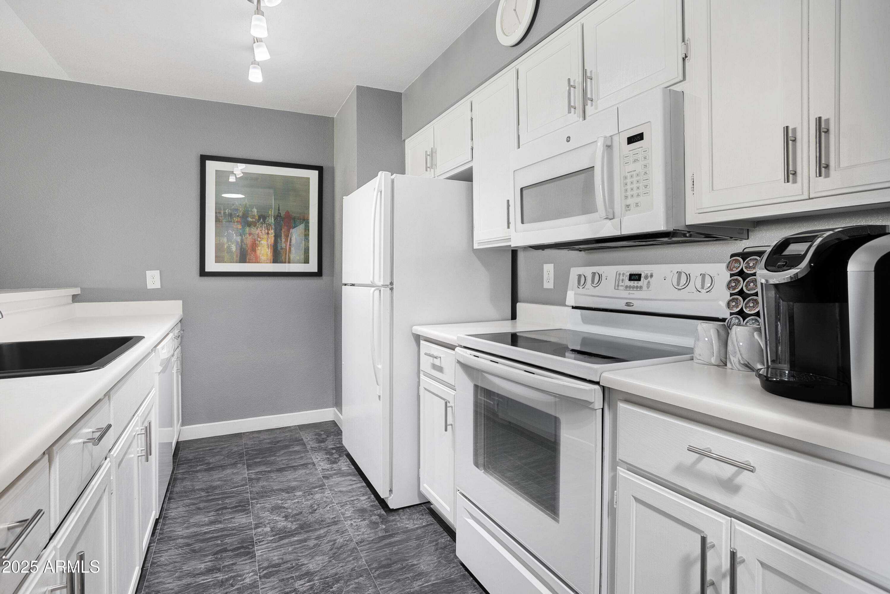 1021 South Greenfield Road, Unit 1195 Mesa, AZ 85206 - Photo 12 of 41 a kitchen with white cabinets and white appliances