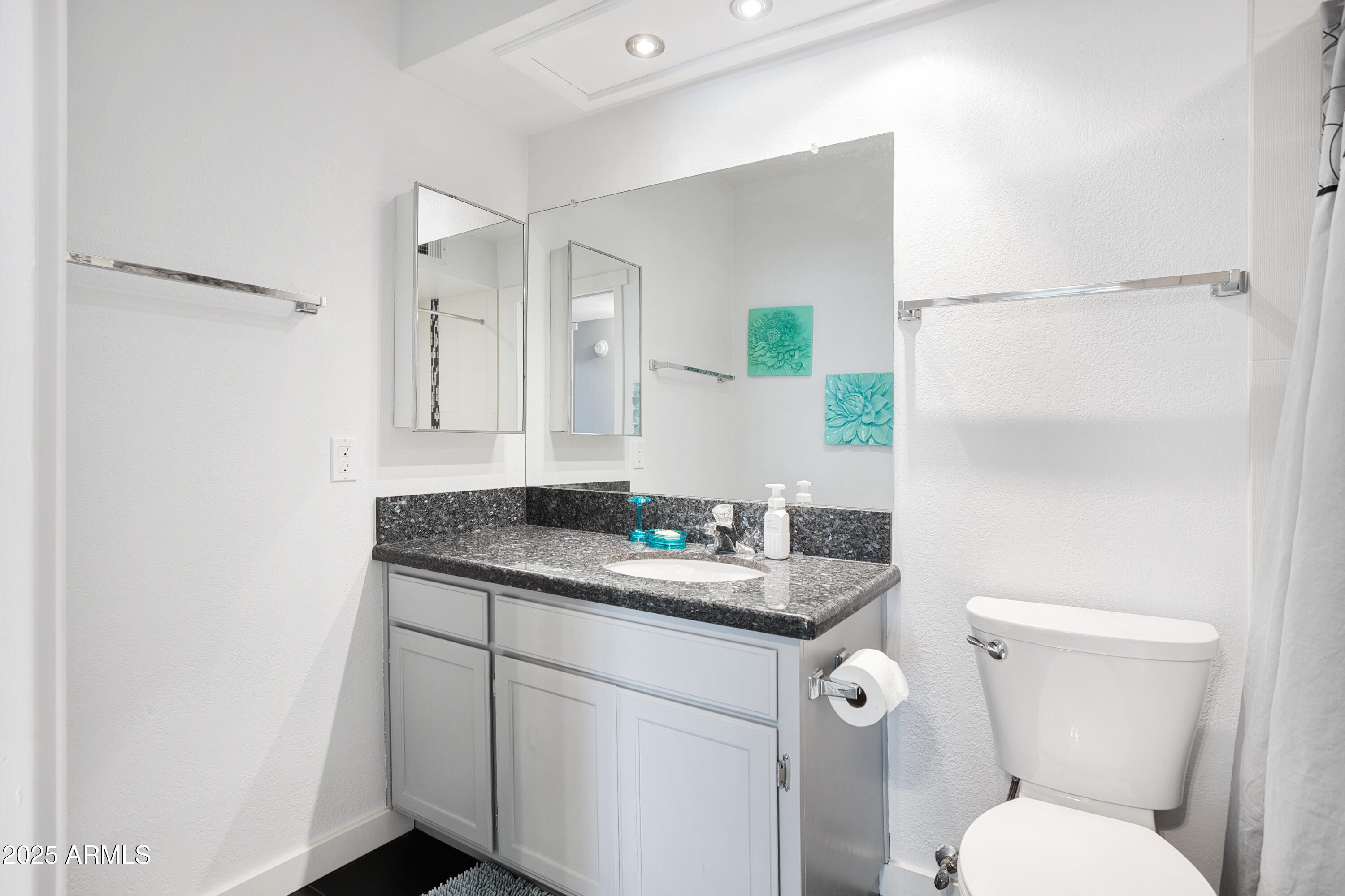 1021 South Greenfield Road, Unit 1195 Mesa, AZ 85206 - Photo 22 of 41 a bathroom with a granite countertop toilet sink and mirror