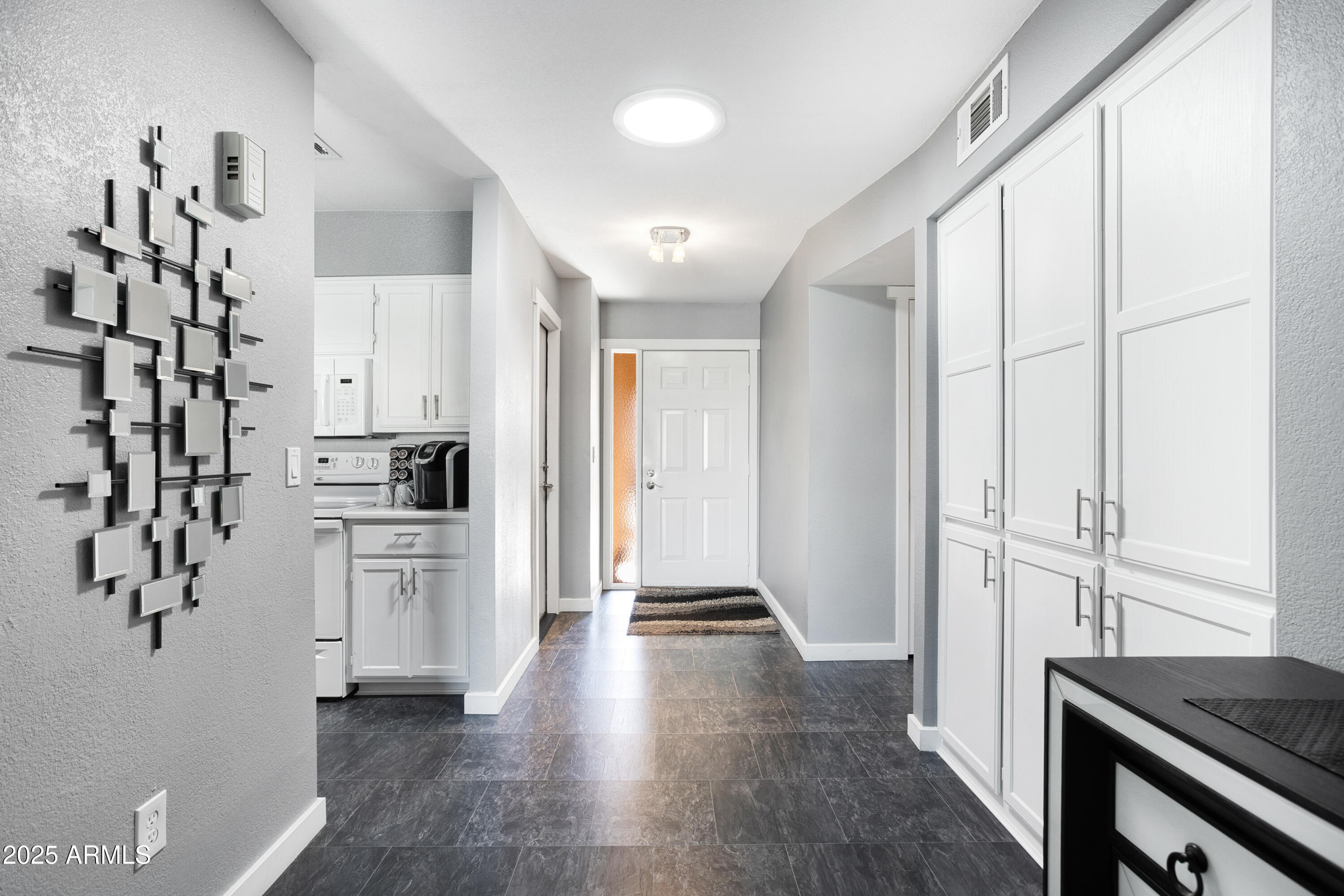 1021 South Greenfield Road, Unit 1195 Mesa, AZ 85206 - Photo 5 of 41 a kitchen with white cabinets and black appliances