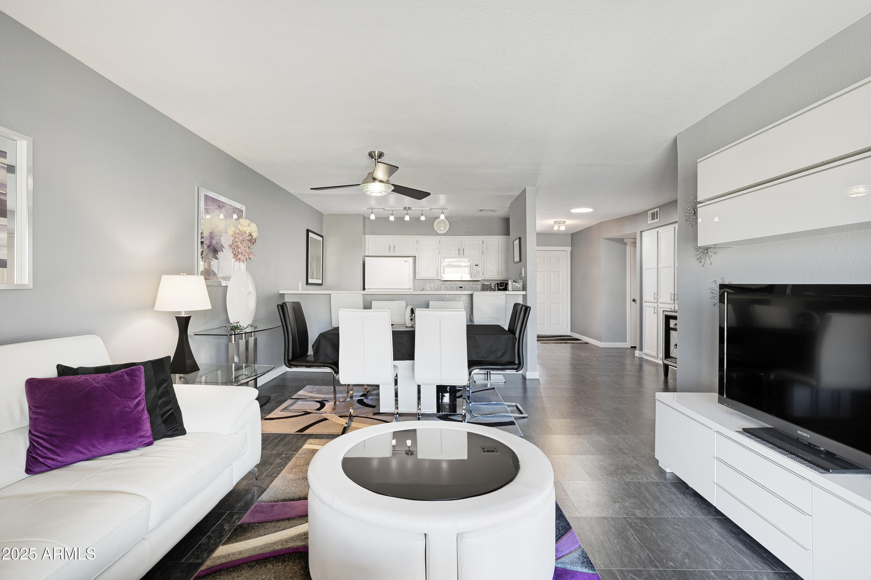1021 South Greenfield Road, Unit 1195 Mesa, AZ 85206 - Photo 9 of 41 a living room with furniture a flat screen tv and kitchen view