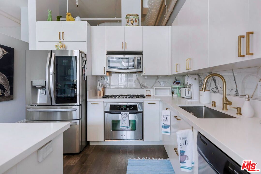 645 West 9th Street, Unit 740 Los Angeles, CA 90015 - Photo 19 of 63 a kitchen with cabinets and stainless steel appliances