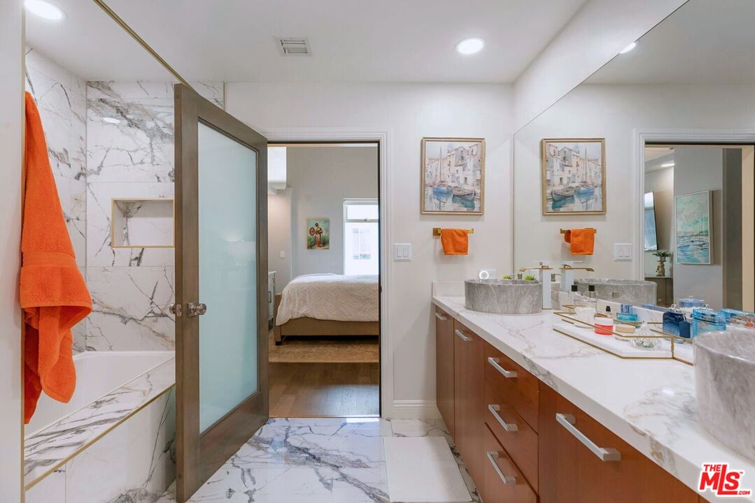 645 West 9th Street, Unit 740 Los Angeles, CA 90015 - Photo 25 of 63 a en suite bathroom with a double vanity sink and a large mirror