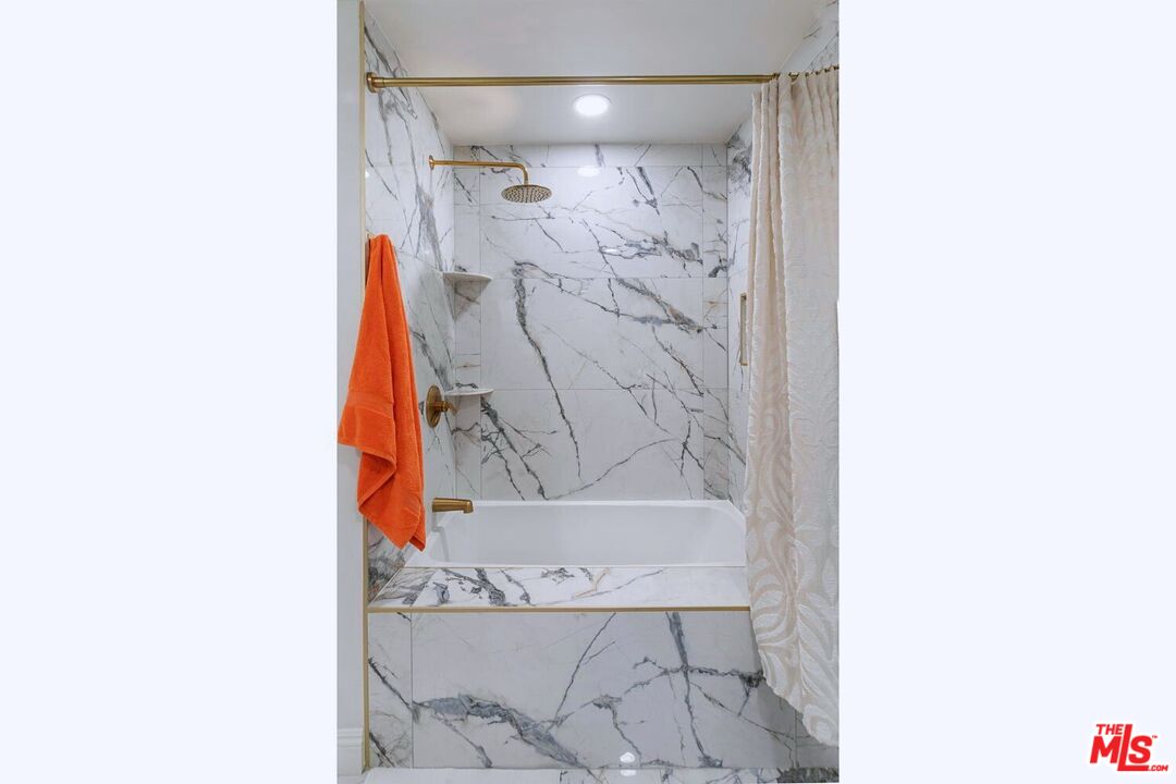 645 West 9th Street, Unit 740 Los Angeles, CA 90015 - Photo 26 of 63 a bathroom with a shower curtain and a bathtub