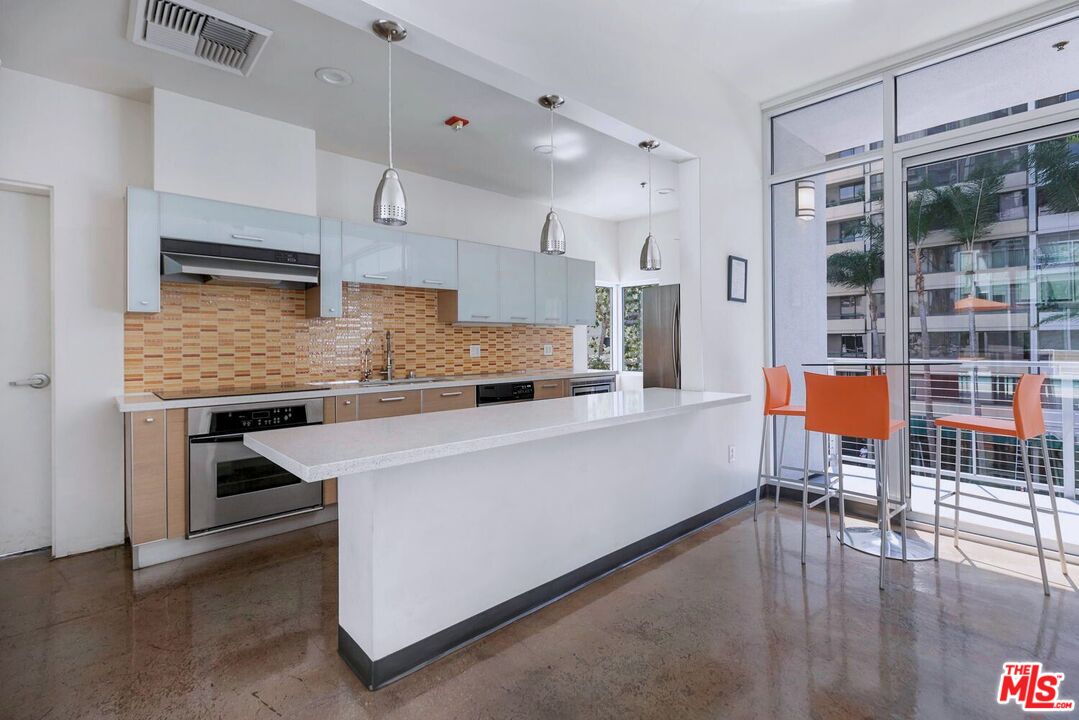 645 West 9th Street, Unit 740 Los Angeles, CA 90015 - Photo 41 of 63 a living room with stainless steel appliances kitchen island granite countertop furniture and a kitchen view